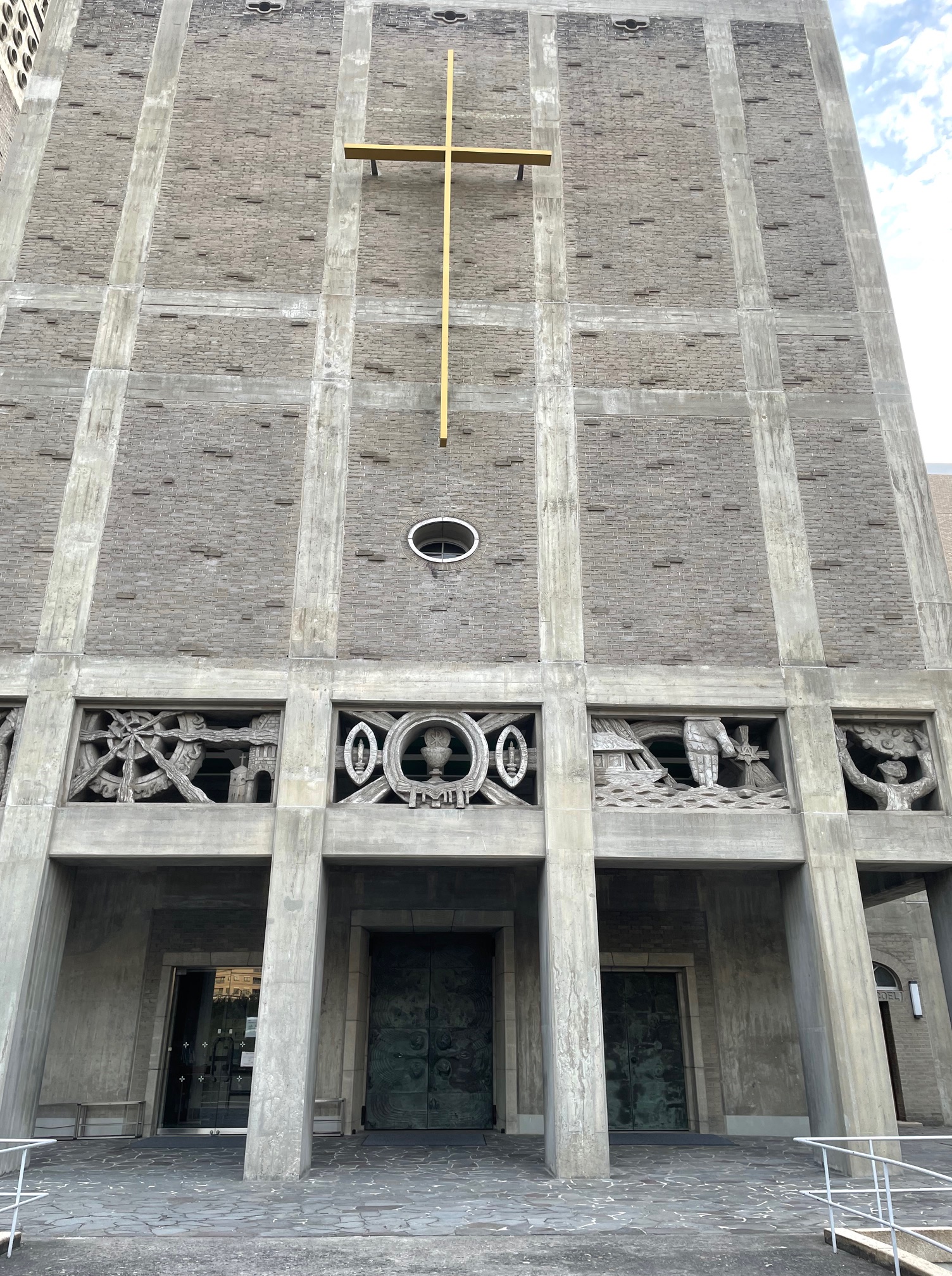 The front facade of the Catholic Noboricho Church – World Peace Memorial Cathedral, showcasing its unique architectural design with intricate carvings and a prominent golden cross.